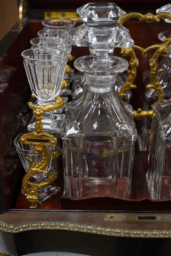 A 19th century Boulle panelled and decorative brass work liqueur cabinet, the interior fitted with gilt fitments, four cut glass decanters and sixteen liqueur glasses, 34cm wide, 26cm high. Condition - minor scratches to